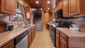 A kitchen with wooden cabinets, a dishwasher, a stove, and a microwave. - Free Tickets | Million Dollar View, Easy Access, Arcade, Fireplace, Hot Tub (Gatlinburg)