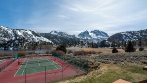 Ein Tennisplatz mit Bergelandschaft im Hintergrund.
