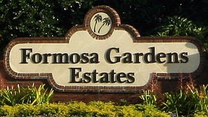 A sign for Formosa Gardens Estates with a palm tree logo.