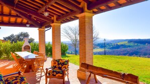 An outdoor patio with a brick table, wooden chairs, and a bench. - House with private pool 90 km northern of Rome (montecampano)