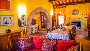 A dining area with a long table, chairs, and a fireplace. - House with private pool 90 km northern of Rome (montecampano)