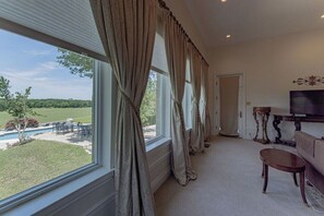 A room with a large window, a television, and a sofa.