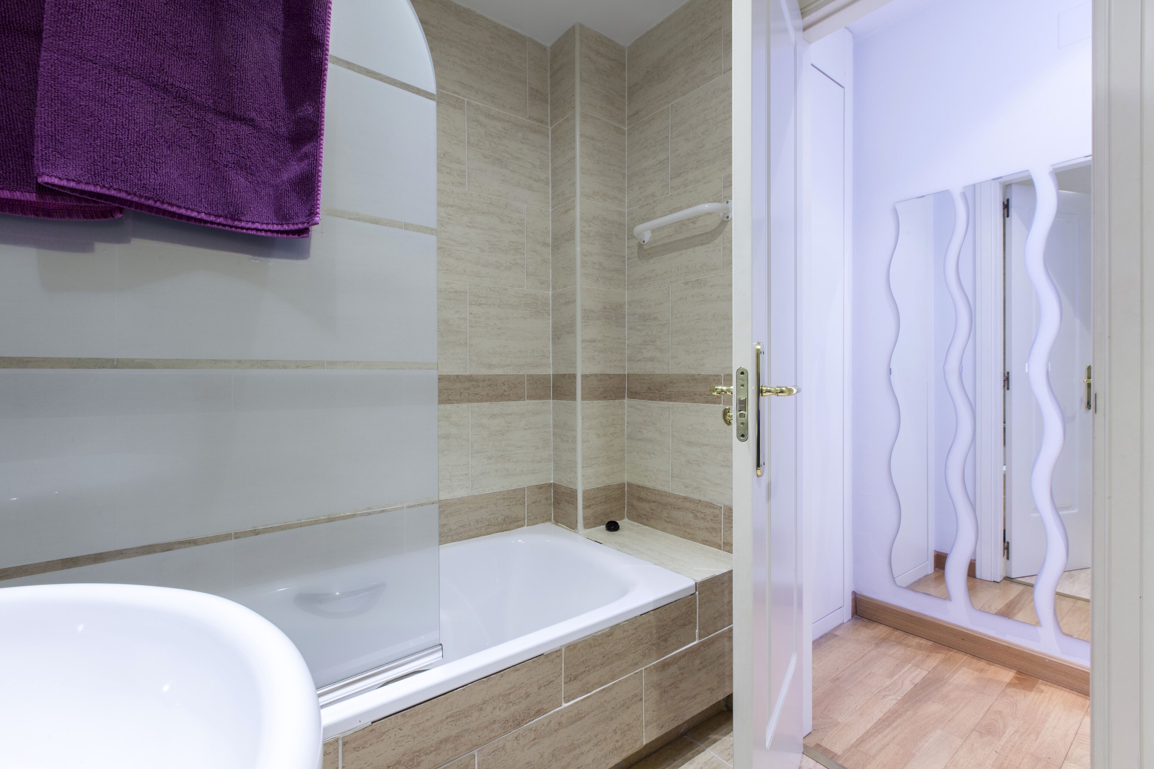 Een bad/douchecombinatie, een bidet, handdoeken, zeep