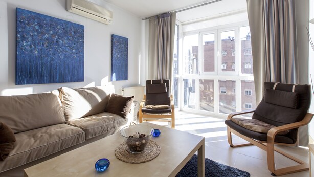 A modern living room with a sofa, two armchairs, a coffee table, and a large window with curtains. - Apartment in the center of Madrid, Rastro (Madrid)