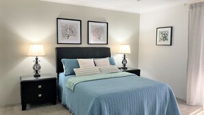 A bedroom with a bed, two nightstands, and three framed pictures on the wall. - Newly Renovated Unit near Forster Main Beach! (Forster)