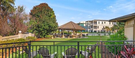 A courtyard with outdoor seating, a pergola, and a view of residential buildings.