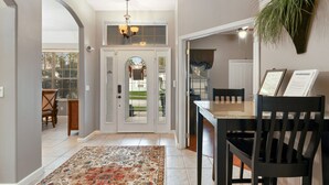A dining area with a table and chairs, a patterned rug, and a hanging plant. - Experience magic! HR Golf Course view 5bd/3b w/pool-spa near all Disney Parks (Davenport)