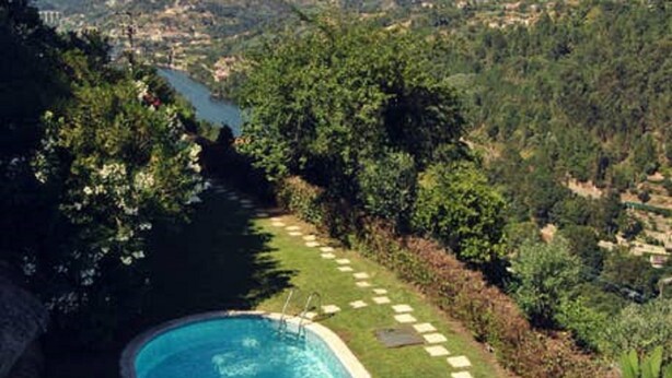 A swimming pool with a clear view of a river and hills in the background.