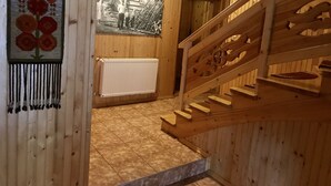 Un interior de madera con una escalera, un radiador y una fotografía enmarcada en la pared.