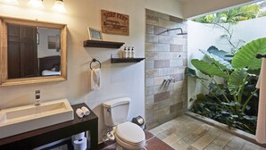 A bathroom with a sink, mirror, toilet, shower, and a plant. - Villa Colibrí, 3 BR, walk to beach, private pool (Santa Teresa Beach)