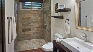 A bathroom with a stone shower, a white sink, and a mirror. - Villa Colibrí, 3 BR, walk to beach, private pool (Santa Teresa Beach)