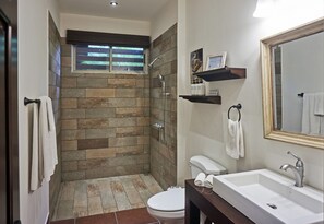 A bathroom with a stone shower, a white sink, and a mirror. - Villa Colibrí, 3 BR, walk to beach, private pool (Santa Teresa Beach)