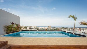 Una piscina en la azotea con vistas a la ciudad y al mar.