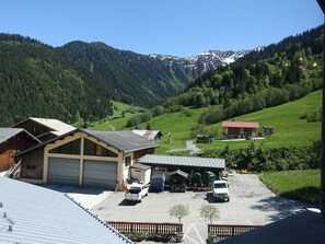 A rural building with a garage, a small shop, and a parking area with vehicles.