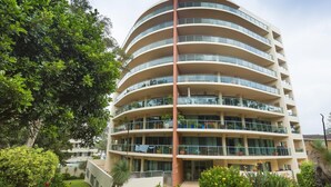 A multi-story building with balconies, surrounded by greenery and trees. - Le Point 101 - Walking distance to Main Beach (Forster)