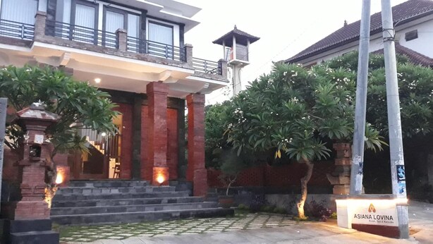 Een gebouw met een balkon, een klein pagode-achtige constructie, en een bordje met de tekst 