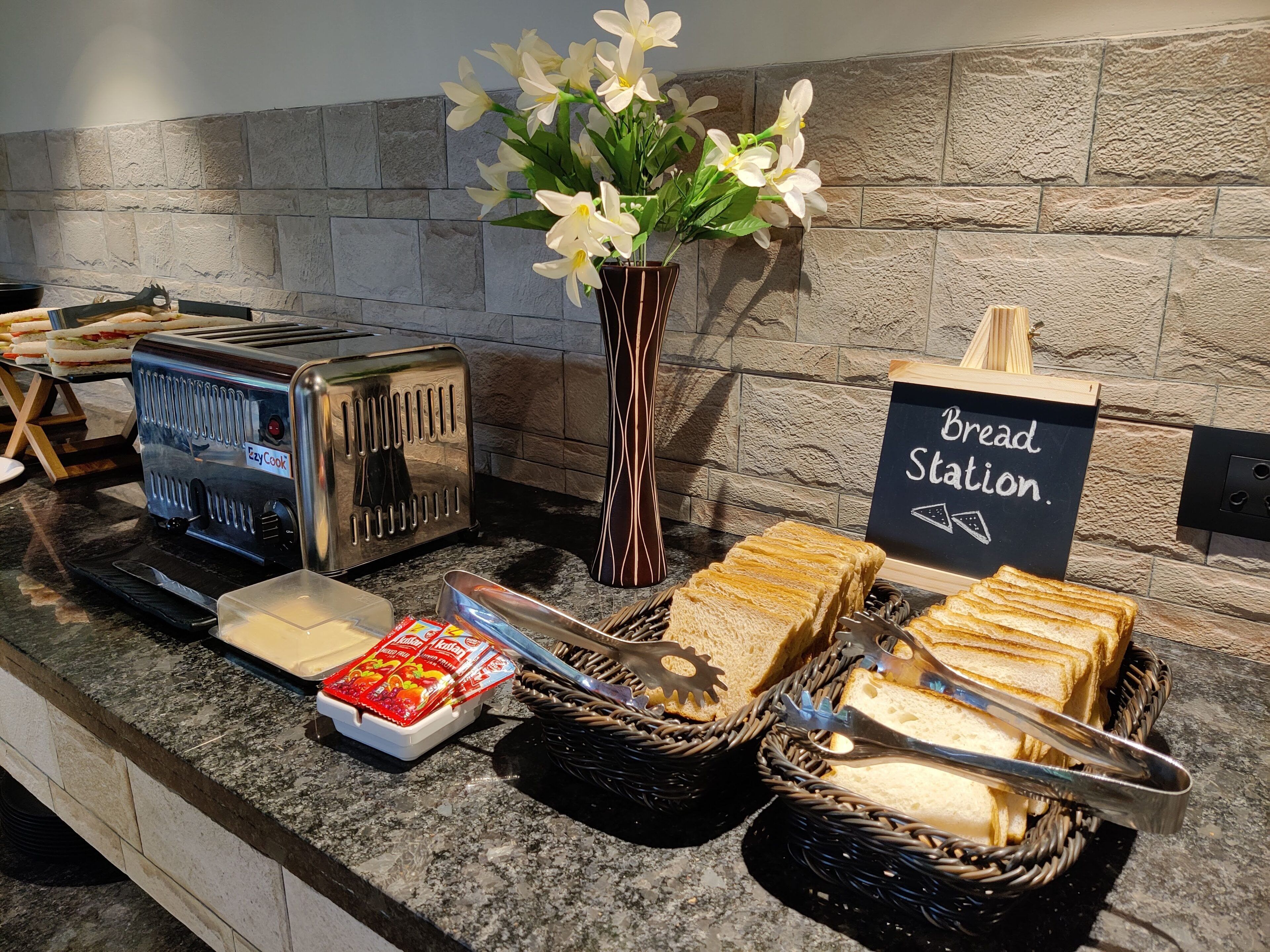 A breakfast station with toasters, bread, and a sign indicating it's a bread station.