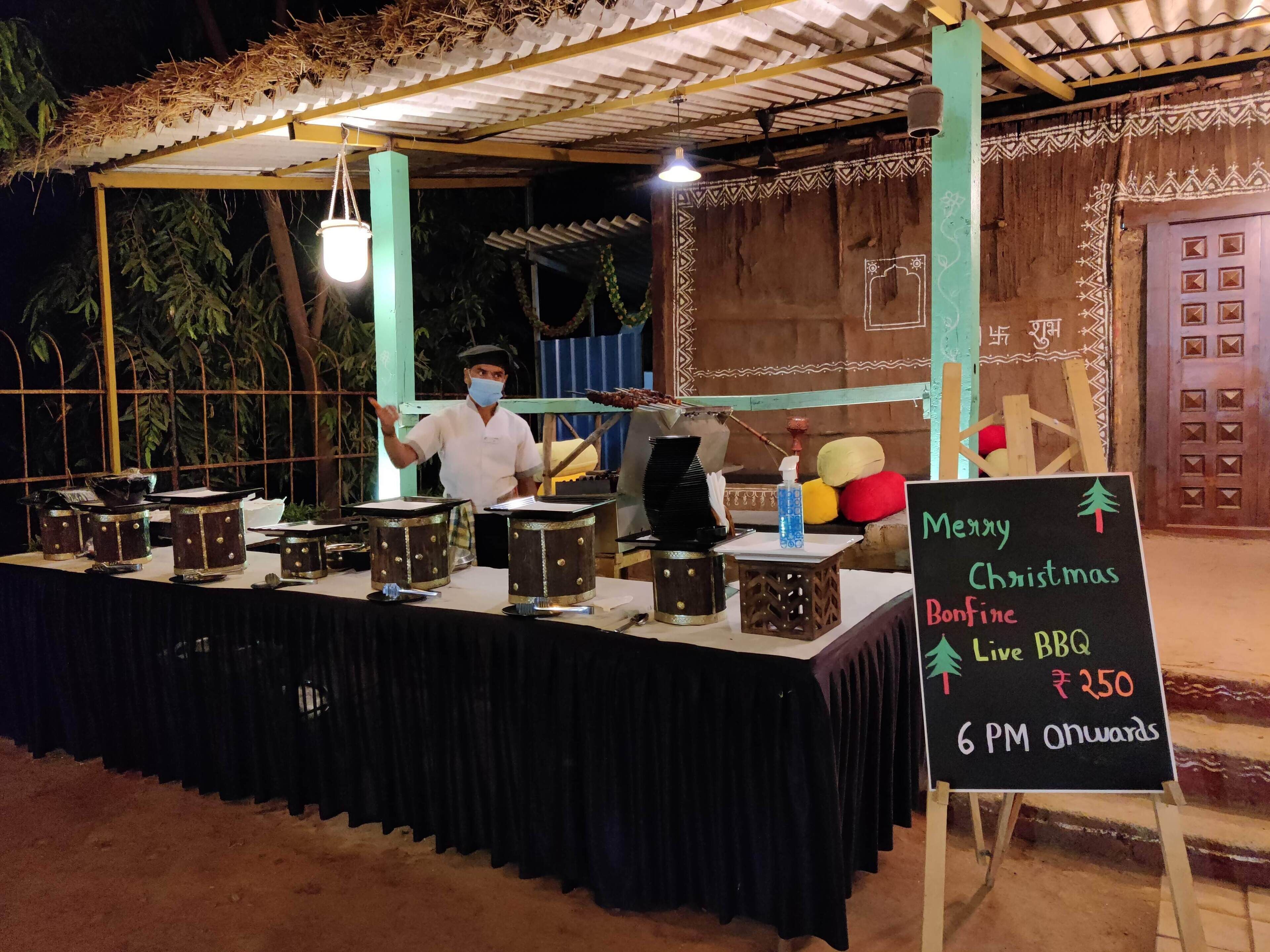 A food stall with a sign advertising a live BBQ event starting at 6 PM.