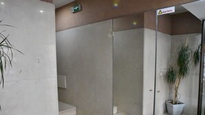 Un moderno vestíbulo de hotel con entrada de vidrio, una escalera y una planta en maceta.