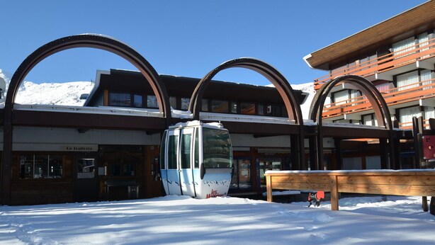 A ski lift station with a cable car, wooden benches, and a building with a sign reading "La Trattoria". - Classic apartment for 4 at La Croisette (Les Menuires)