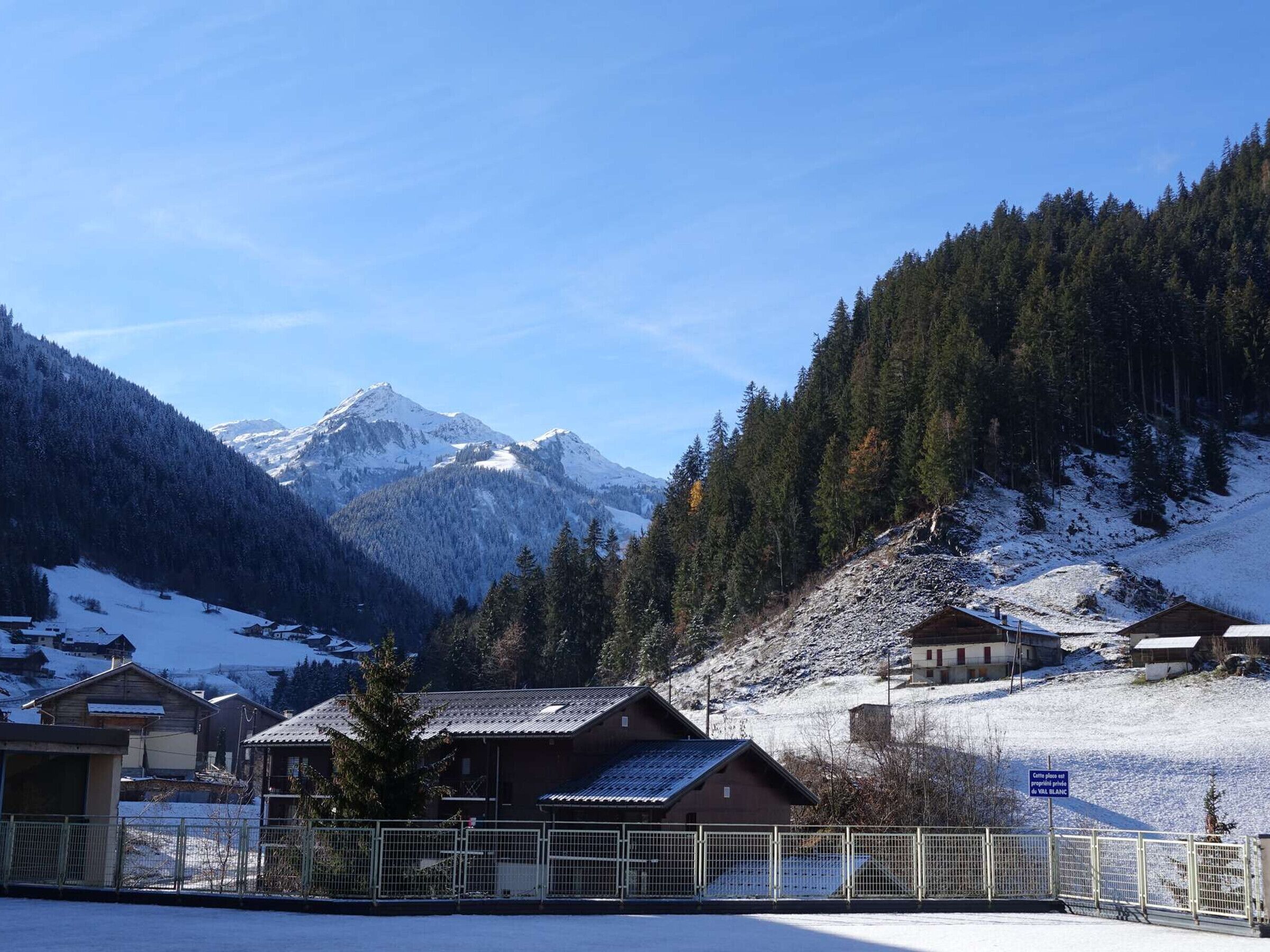 A mountainous landscape with snow-covered houses and a clear sky.