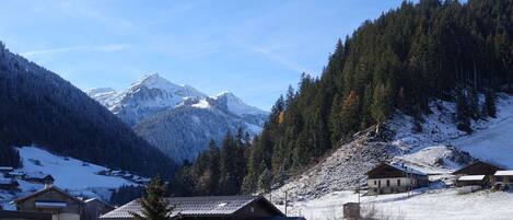 A mountainous landscape with snow-covered houses and a clear sky.