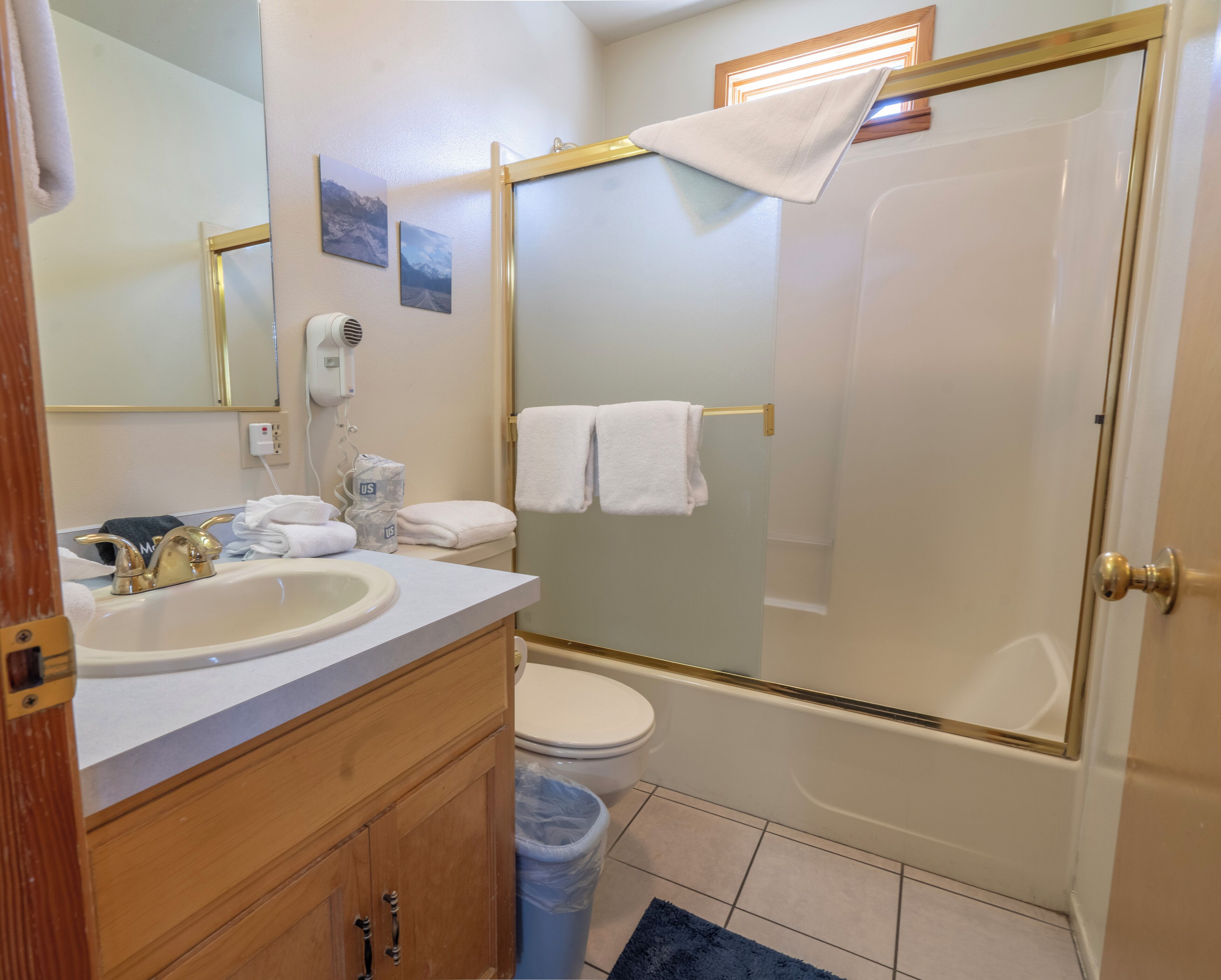 A bathroom with a sink, mirror, toilet, and shower.