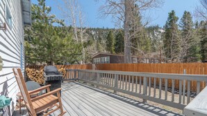 A wooden deck with a rocking chair, a grill, and a wooden fence. - June Lake Lodge- Centrally located - short walk to JLB, The General Store, both Gull and June Lakes (June Lake)