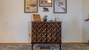 A wall with three framed posters, a wooden cabinet with a geometric pattern, and a small plant on top. - June Lake Lodge- Centrally located - short walk to JLB, The General Store, both Gull and June Lakes (June Lake)