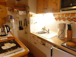 A kitchen with wooden cabinets, a coffee maker, a sink, and a stove. - Charming 4-5 Person Apartment, Well-Equipped, Central Location, Elevator, 50m to Slopes & Shops (Arêches-Beaufort)