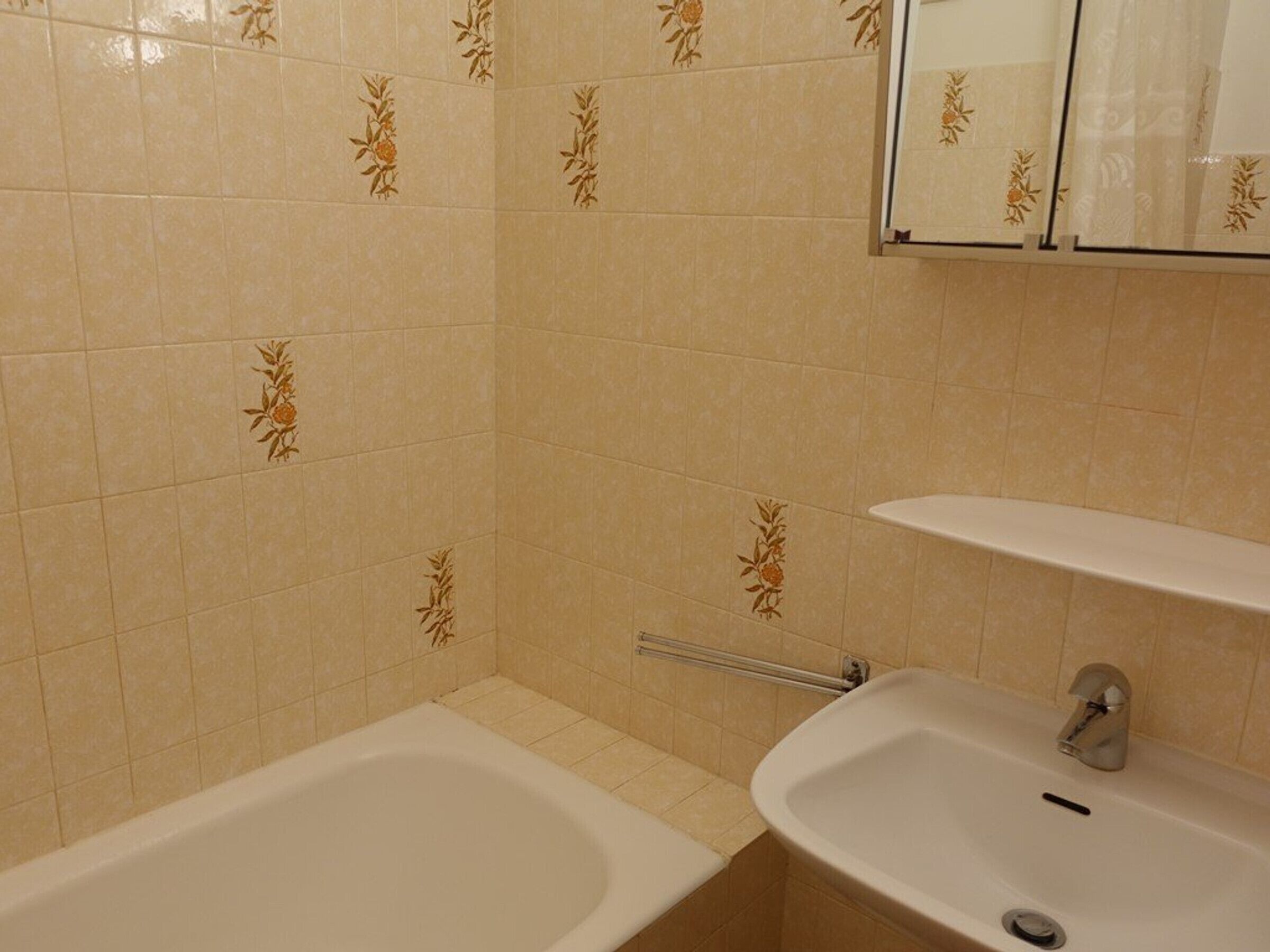 Une salle de bain avec une baignoire, un lavabo et un miroir.