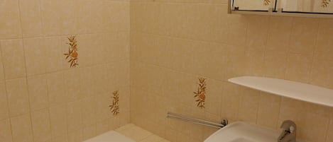 Une salle de bain avec une baignoire, un lavabo et un miroir.