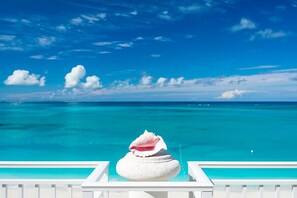 Vista della piscina con cielo azzurro e mare turchese.