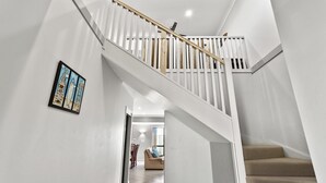 A modern staircase with white railings and a wooden handrail, leading to a second floor. - 3-45 Park Street - Spacious Townhouse (EVANS HEAD)