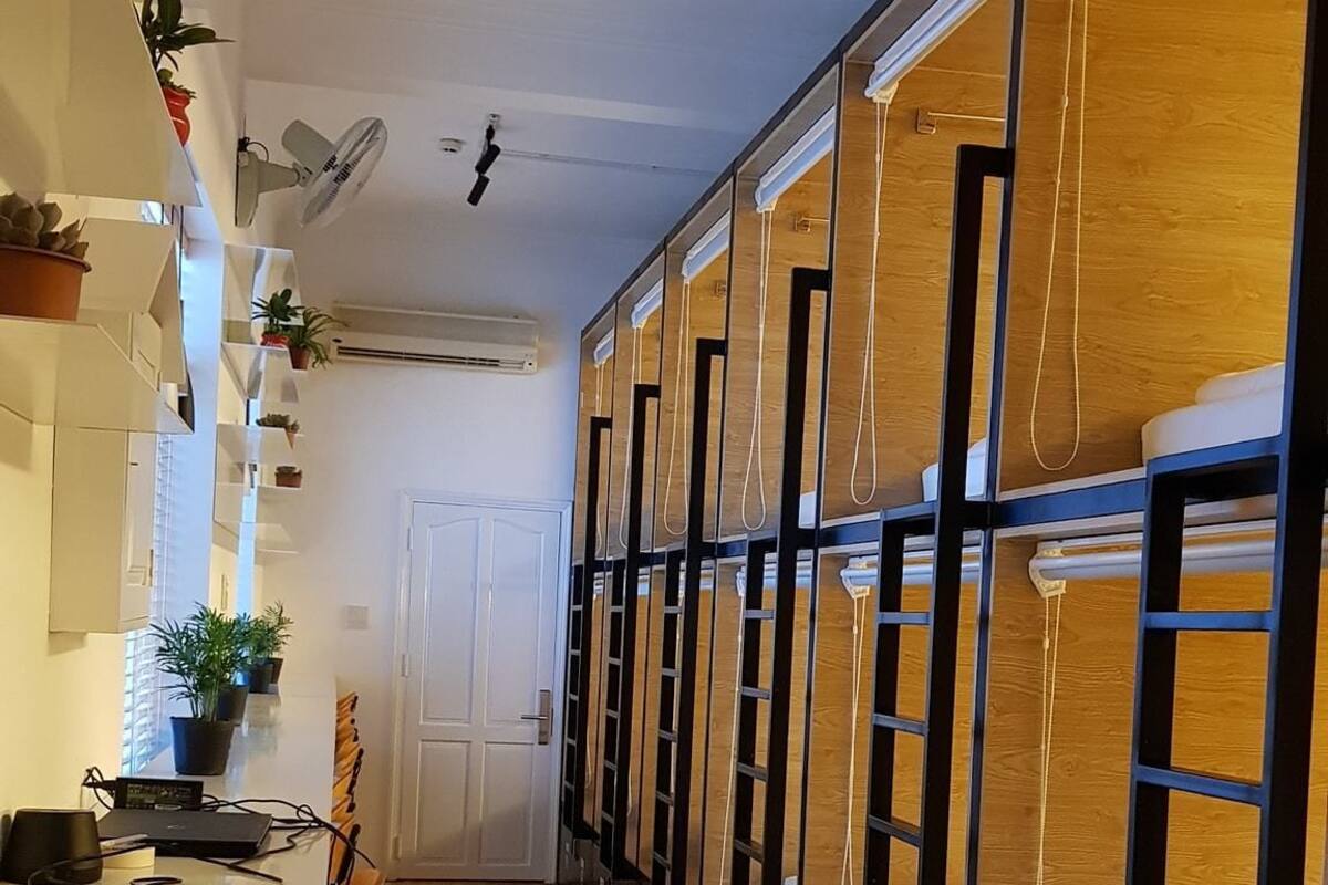 A hotel room with bunk beds, a desk with a laptop, and a chair.