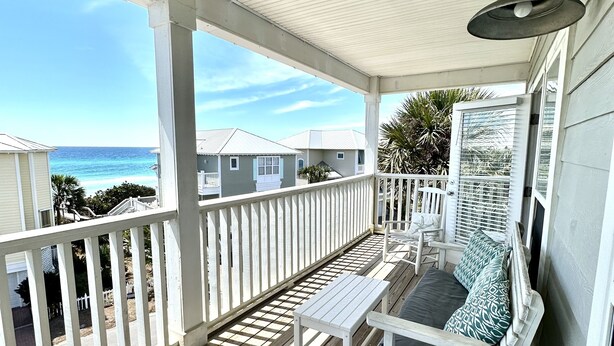 A wooden deck with a white railing, a bench, and a hanging light fixture. - Private Beach, 5 BR w/awesome views, private pool & golf cart (Santa Rosa Beach)