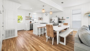 A modern kitchen with white cabinetry, wooden flooring, and pendant lighting. - Private Beach, 5 BR w/awesome views, private pool & golf cart (Santa Rosa Beach)