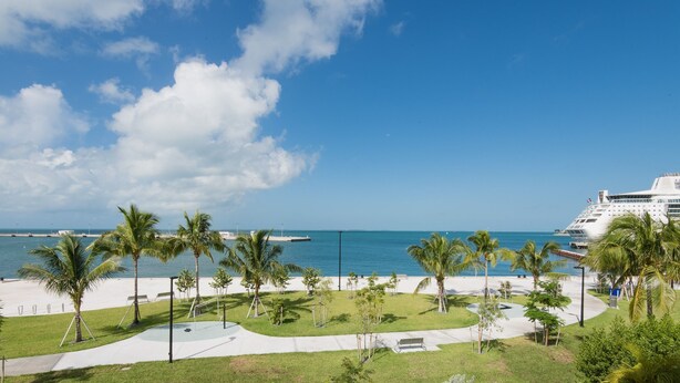 A coastal view with a beach, palm trees, and a cruise ship in the background. - Island Oasis at the Truman Annex in Key West (Key West)