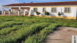 Un edificio de dos plantas con techo de tejas, un porche cubierto y un sendero pavimentado que conduce a la entrada.