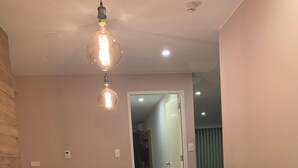 Een vergaderruimte met een lange tafel, zes stoelen en een hanglamp.
