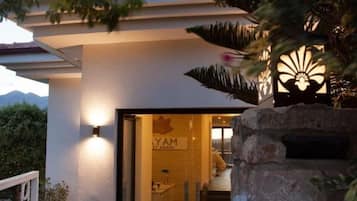 A hotel entrance with a sign reading "PAYAM GUEST HOUSE" and a pathway leading to the interior.