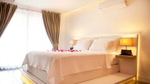 A modern hotel room with a large bed, bedside lamps, and a view of the outdoors.