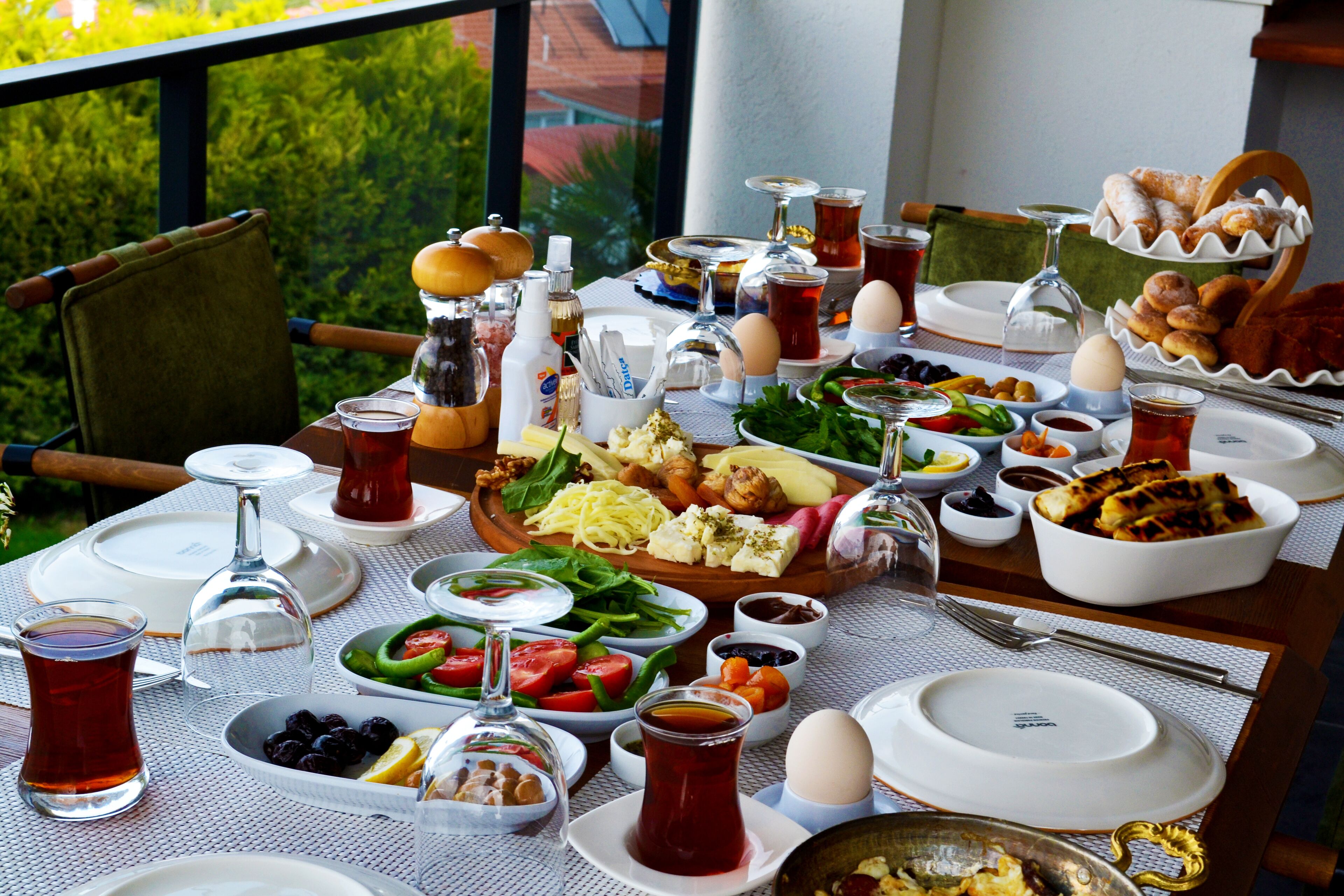 Una mesa dispuesta para el desayuno con diferentes platos, bebidas y cubiertos.