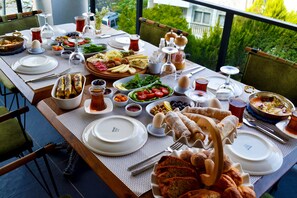 A table set for a meal with various dishes, glasses, and utensils. - Payam Guest House (Datça)