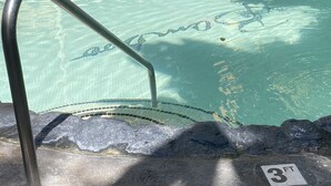 Piscina clara con una escalera metálica y un indicador de profundidad de 3 pies.