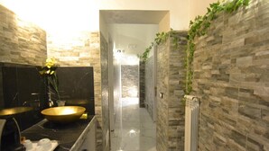 A modern bathroom with a black marble vanity, gold basin, and a mirror. - Popolo Relax (Rome)