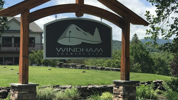 Uma pérgola de madeira com uma placa do Windham Country Club.