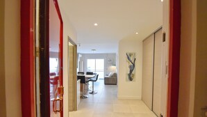 Um corredor com área de refeições, um sofá e um quadro na parede.