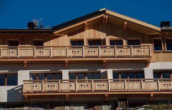 A multi-story building with balconies and large windows.