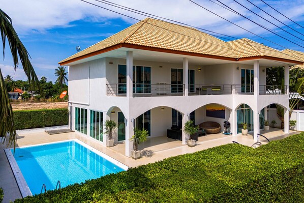 A two-story house with a swimming pool, large windows, and a covered patio area. - Modern 4 Bedrooms Pool Villa - VY (Hua Hin)